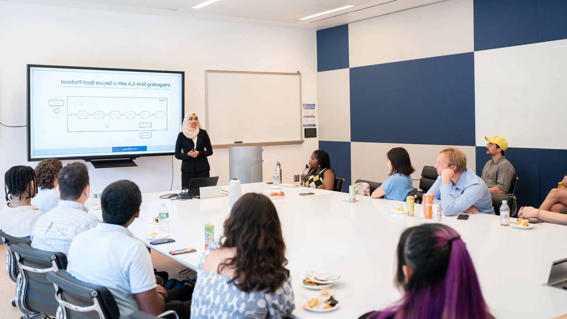 student giving a presentation in a conference room with peers